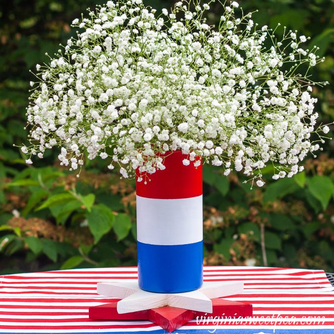 Red, white, and blue striped vase filled with Baby's Breath.