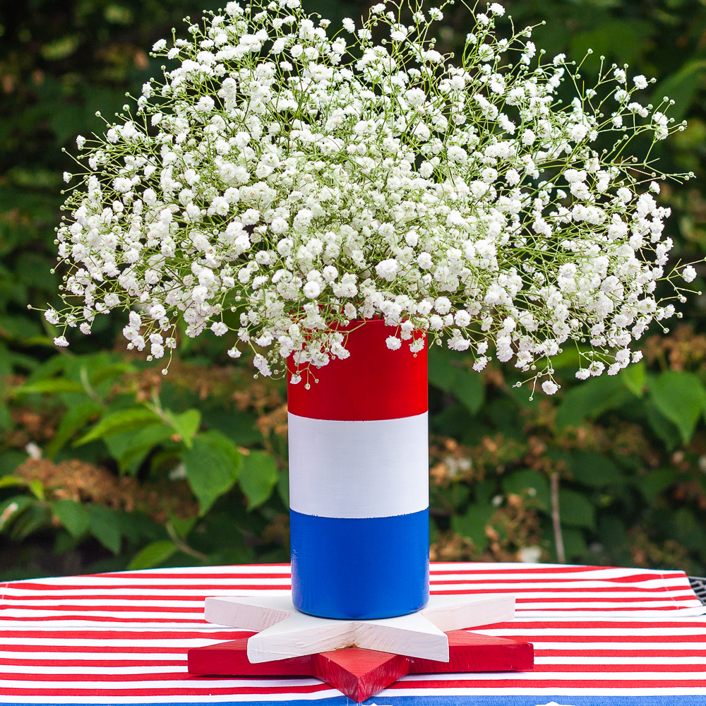 Red, white, and blue striped vase filled with Baby's Breath.