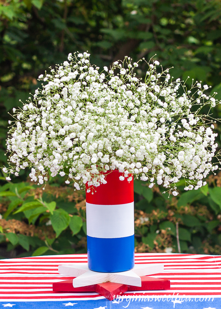 Red, white, and blue striped vase filled with Baby's Breath.