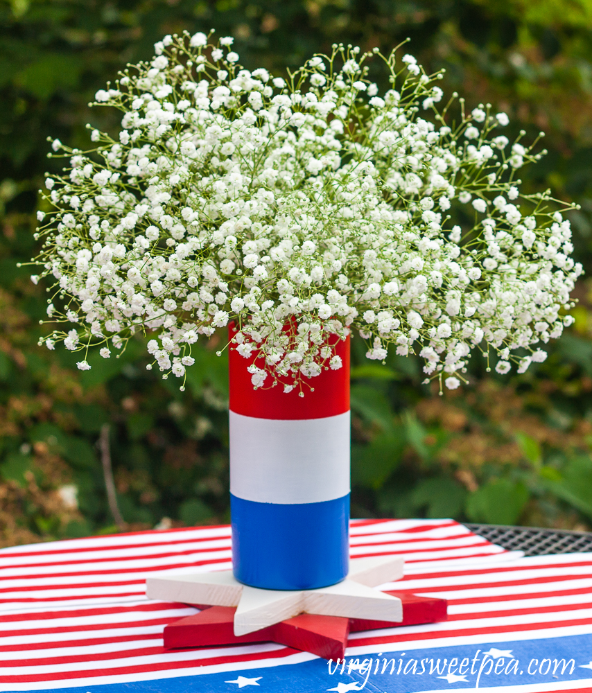 Red, white, and blue striped vase filled with Baby's Breath.