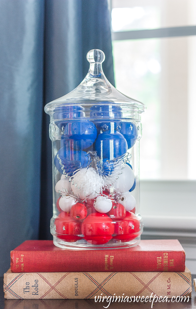 Patriotic Vignette with 1976 eagle jar with red, white, amd blue filler made from wood beads and ping-pong balls stacked on two vintage books