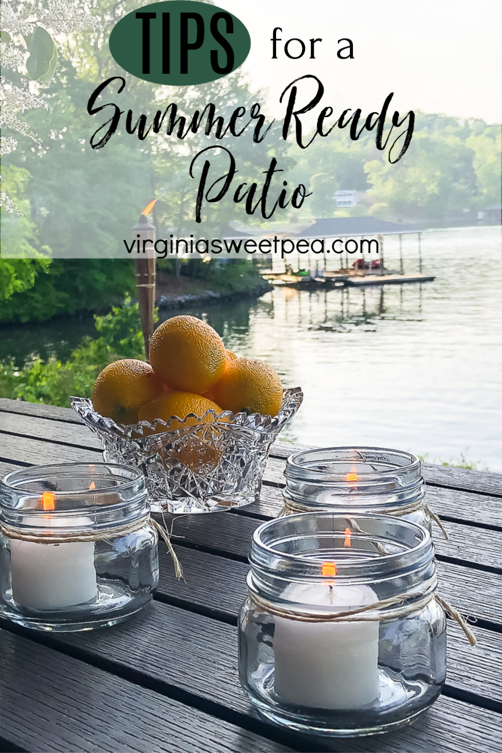 Patio overlooking a lake with candles and a glass bowl filled with lemons.