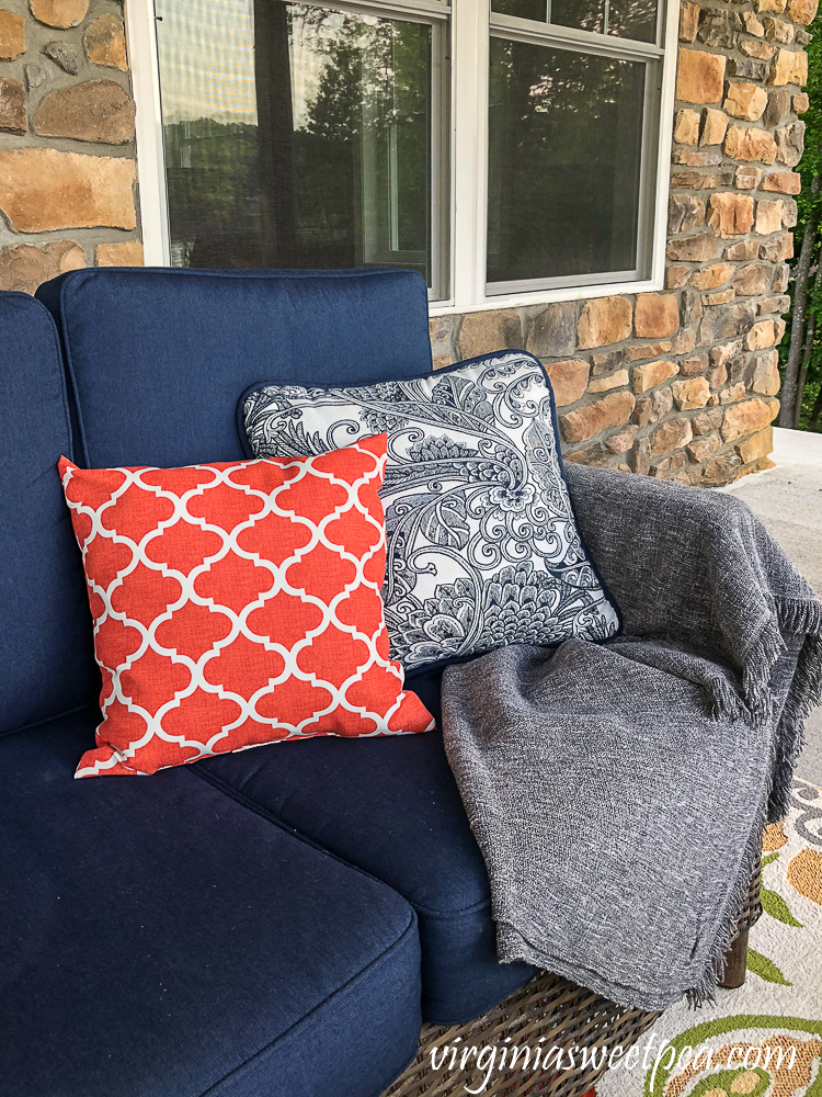 Pillows and a throw on a sofa on a lake house patio