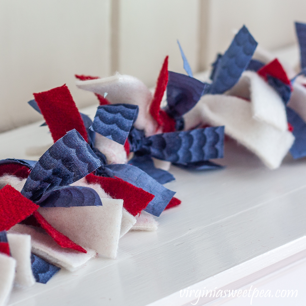 Rag garland made with blue quilting fabric, red wool, and white fleece