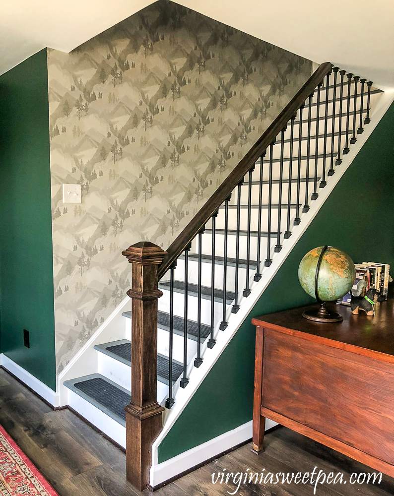 Wallpapered stairwell leading to a basement in a lake house