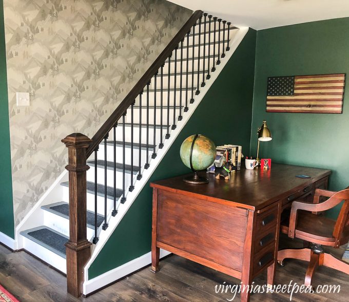 Wallpapered stairwell leading to a basement in a lake house