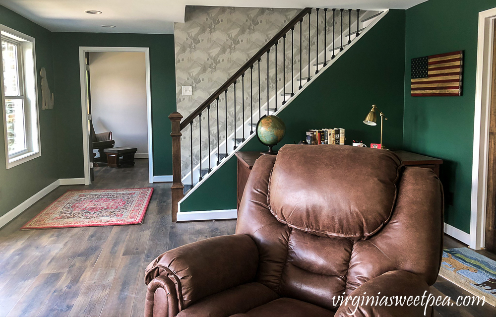 Wallpapered stairwell leading to a basement in a lake house