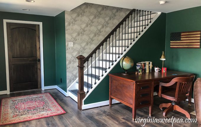 Wallpapered stairwell leading to a basement in a lake house