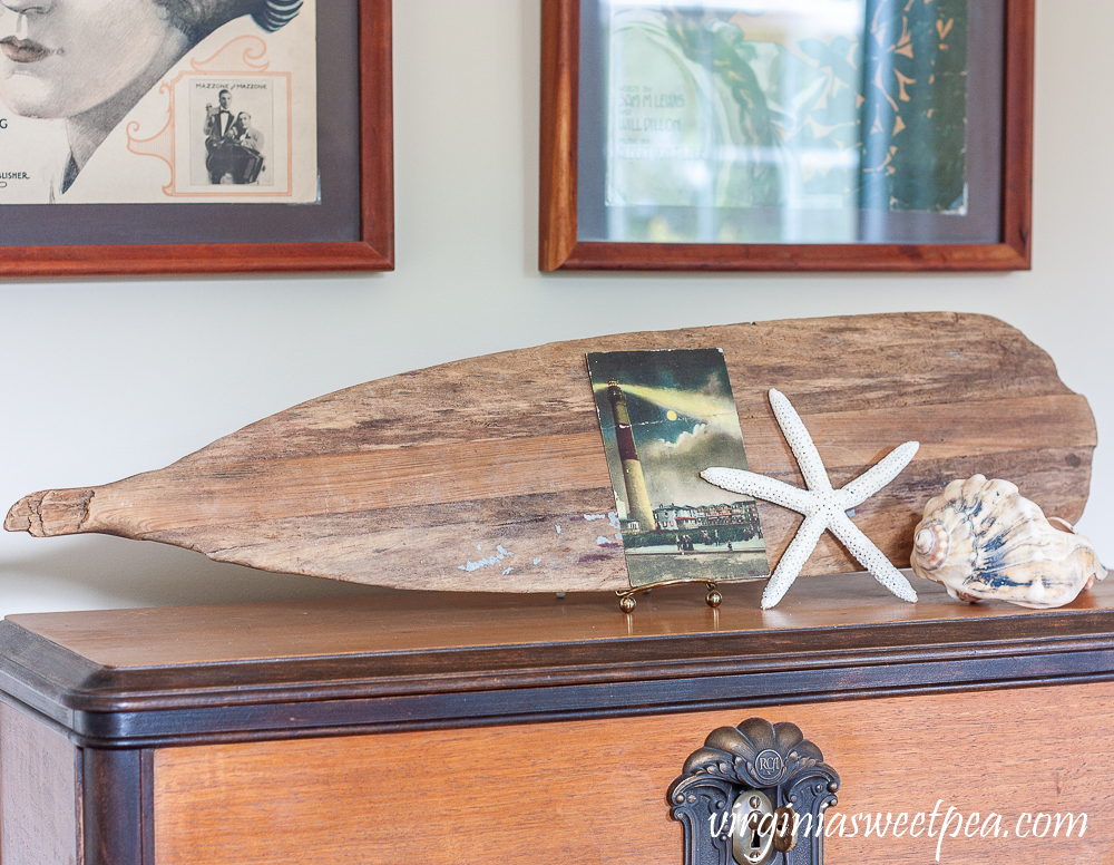 Old oar on display in a living room decorated for summer with a coastal theme.