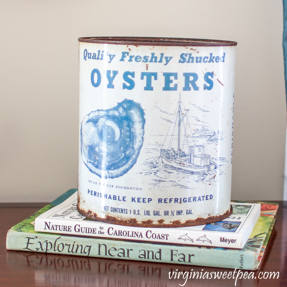 vintage oyster tin on top of two books