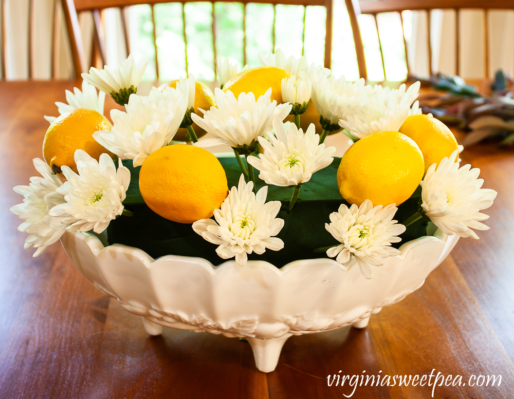 Lemons and flowers on skewers arranged in white milk glass Indiana fruit bowl