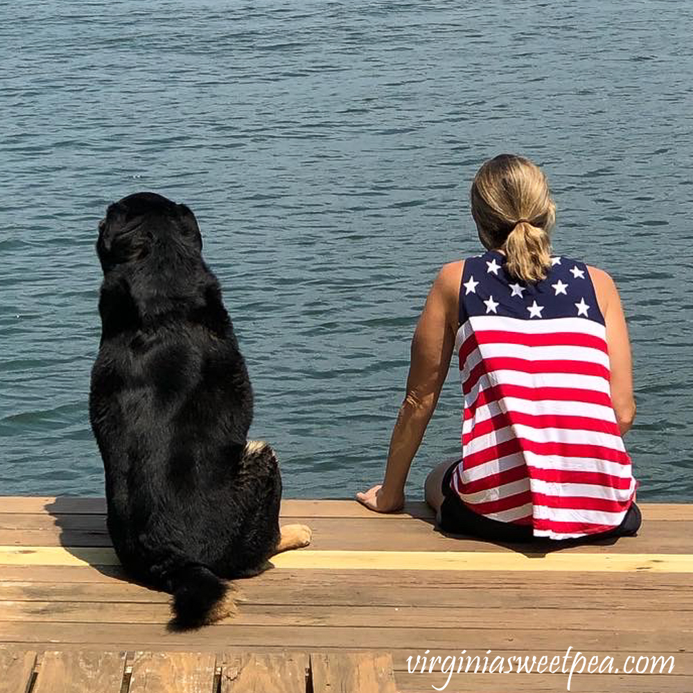 Dog and woman sitting on a dock