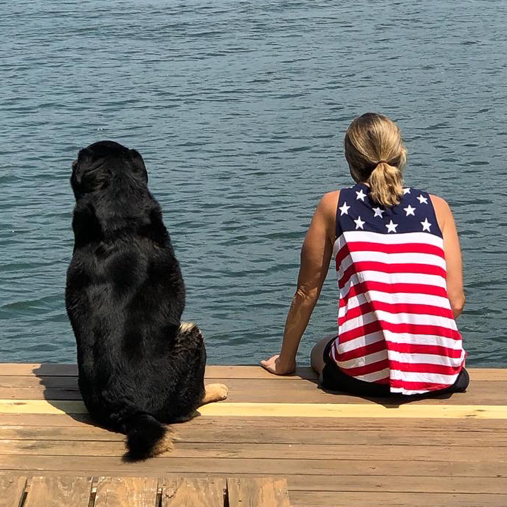 Dog and woman sitting on a dock