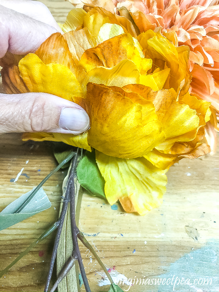 Adding greenery to a fall wreath