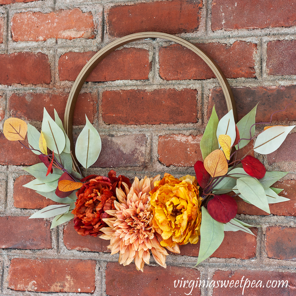 Fall Hoop Wreath hanging on a brick wall