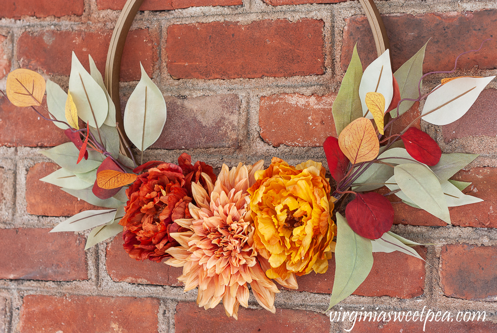 Fall colored peonies and a dahlia with eucalyptus on a fall hoop wreath