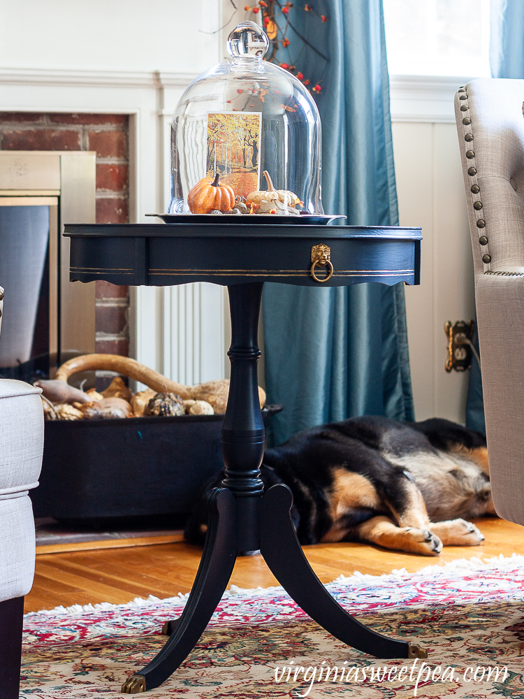 Living room decorated for fall with a sleeping dog by the fireplace