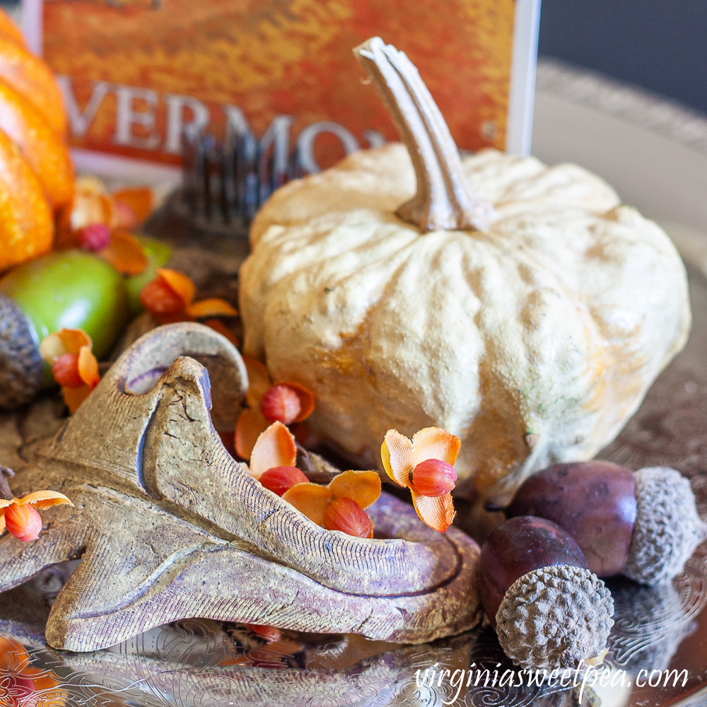 Preserved gourd shaped like a pumpkin, pottery leaf, bittersweet, acorns, and fall Vermont postcard