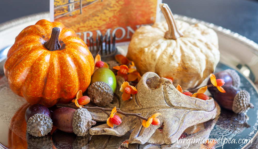 Faux pumpkin, preserved gourd, acorns, bittersweet, pottery leaf and Vermont fall postcard on a silver tray