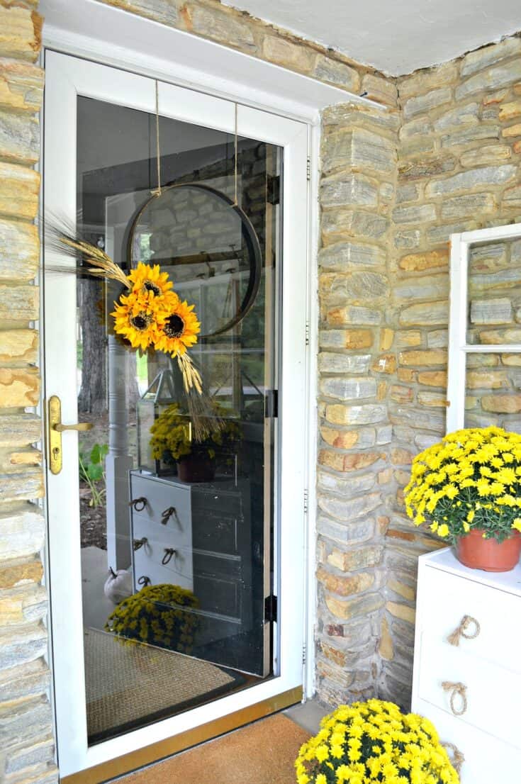 Hoop wreath decorated for fall with sunflowers and wheat