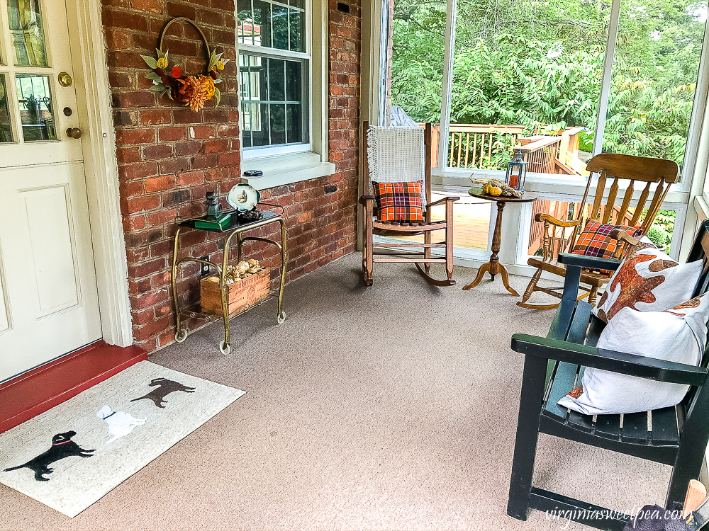 Enclosed porch decorated for fall