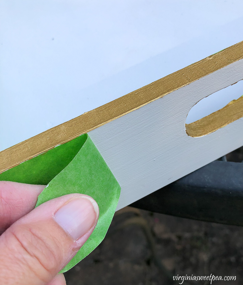 Removing Frog Tape from wooden tray painted white with gold edges