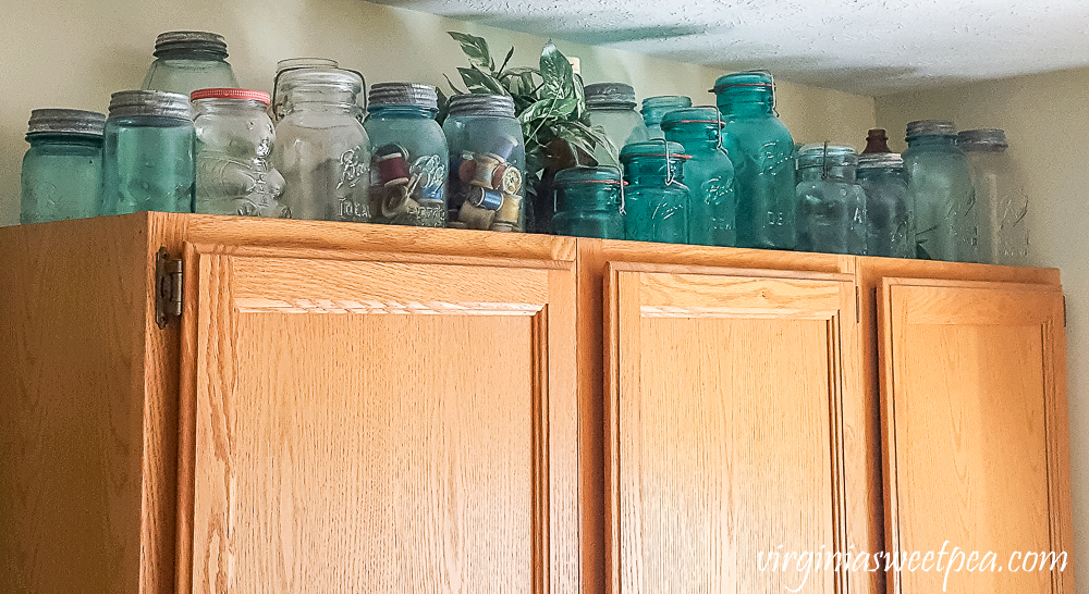 vintage canning jars displayed on top of a cabinet