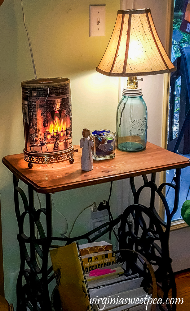 Antique sewing table topped with an Econolite, lamp made from a vintage canning jar, angel, and sea glass.