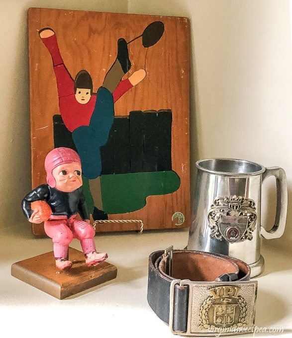 Wood football puzzle from the 1940s and celluloid football player from the 1930s and Virginia Tech corp of cadets belt with belt buckle from the late 50s to early 60s with a Virginia Tech metal mug