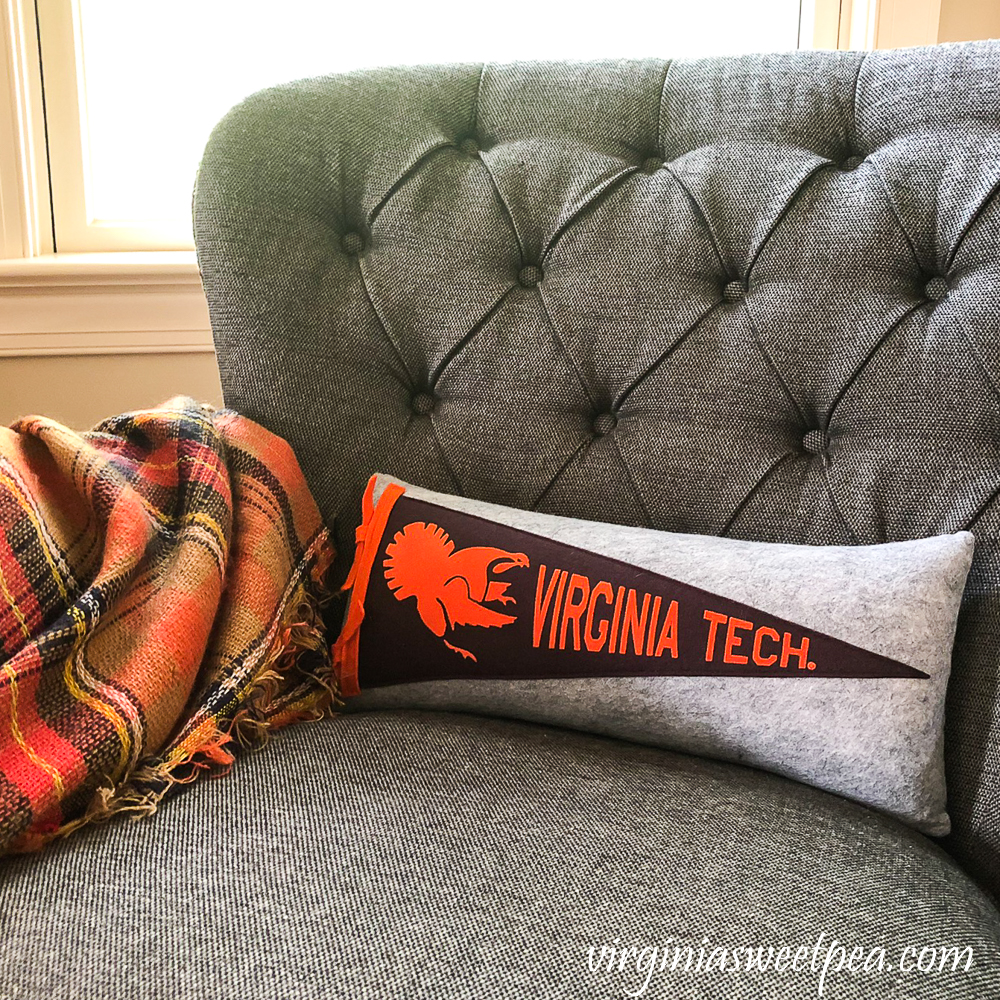 Grey chair with an orange plaid throw and Virginia Tech pillow