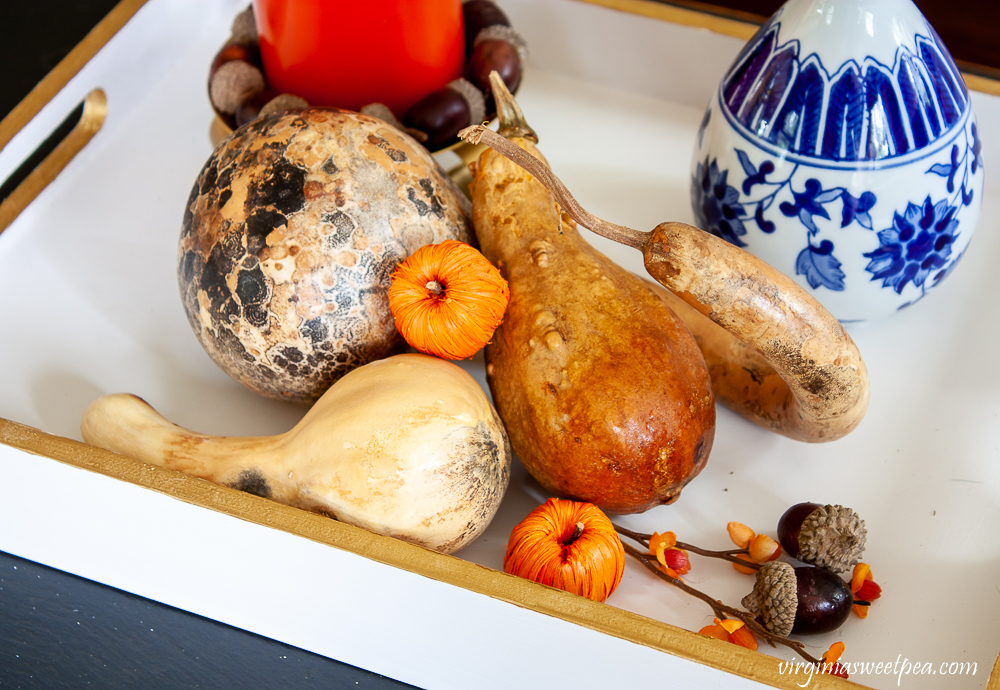 Wood tray painted white and gold styled for fall with dried gourds