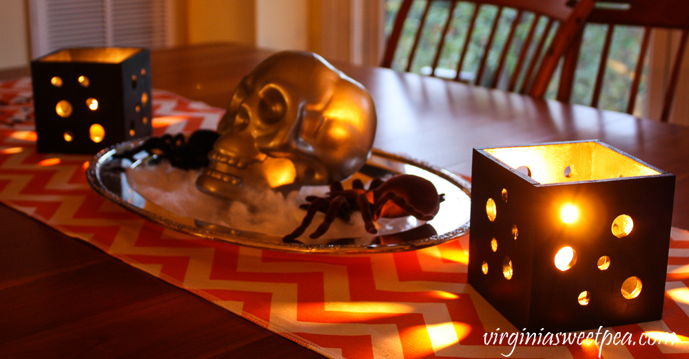 Halloween table decorations with candle holders and skull and spider centerpiece