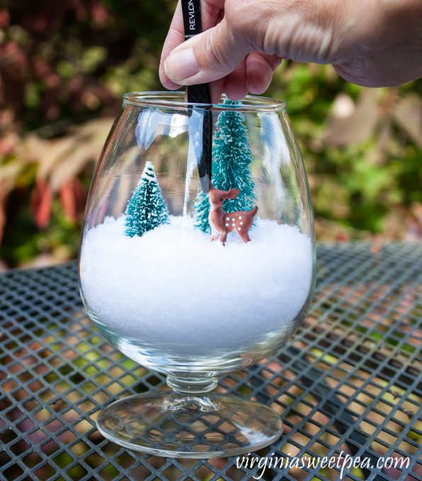 Brandy sniffer with snow ,two miniature trees, and a deer being added with tweezers