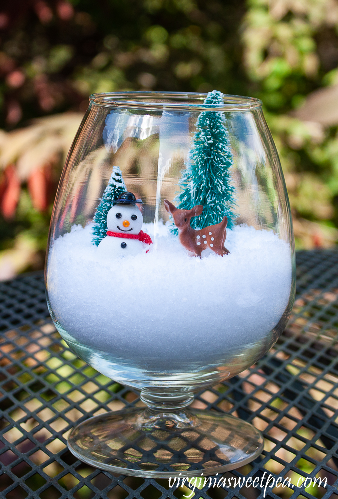 Brandy sniffer with snow ,two miniature trees, deer, and a snowman