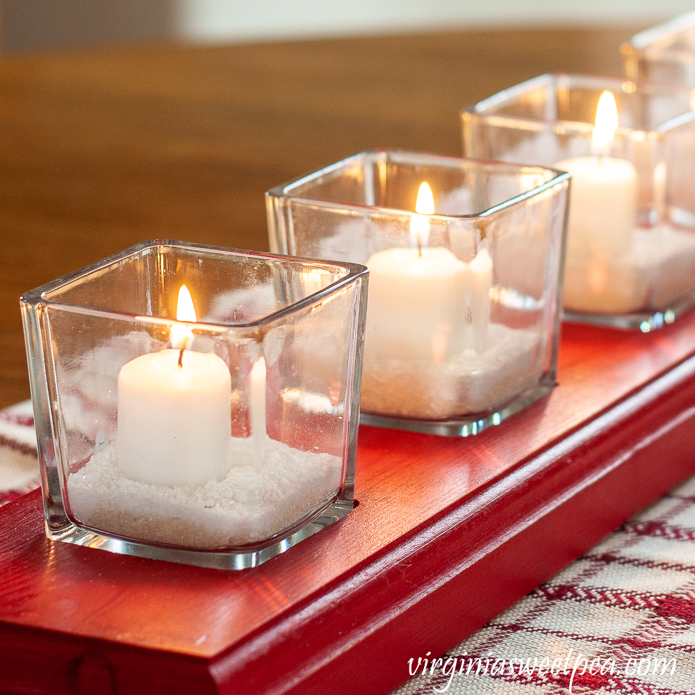 White votive candles in glass votives with Epsom salt on a red handmade glass votive holder.