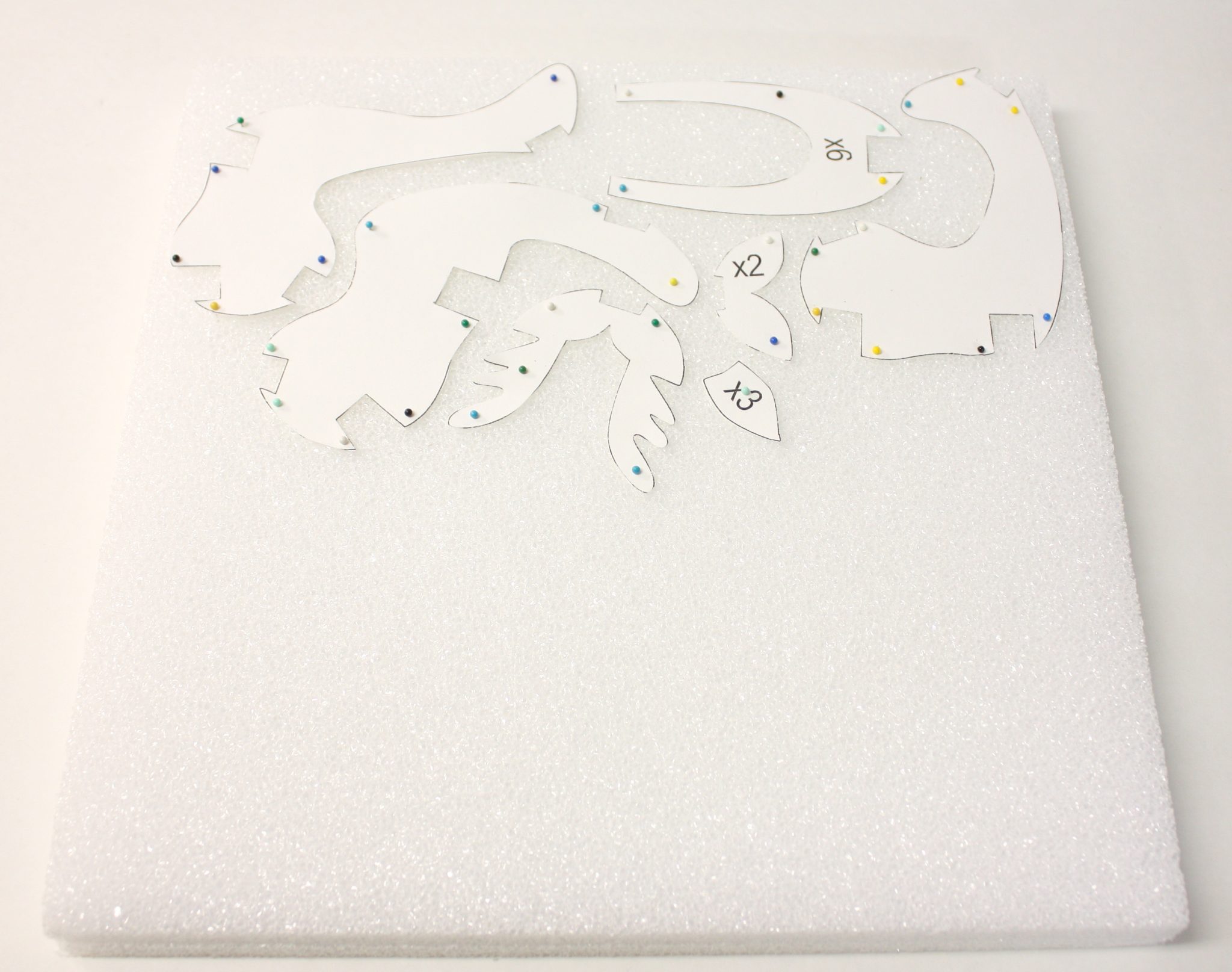 Styrofoam sheet with reindeer template pieces pinned to it.