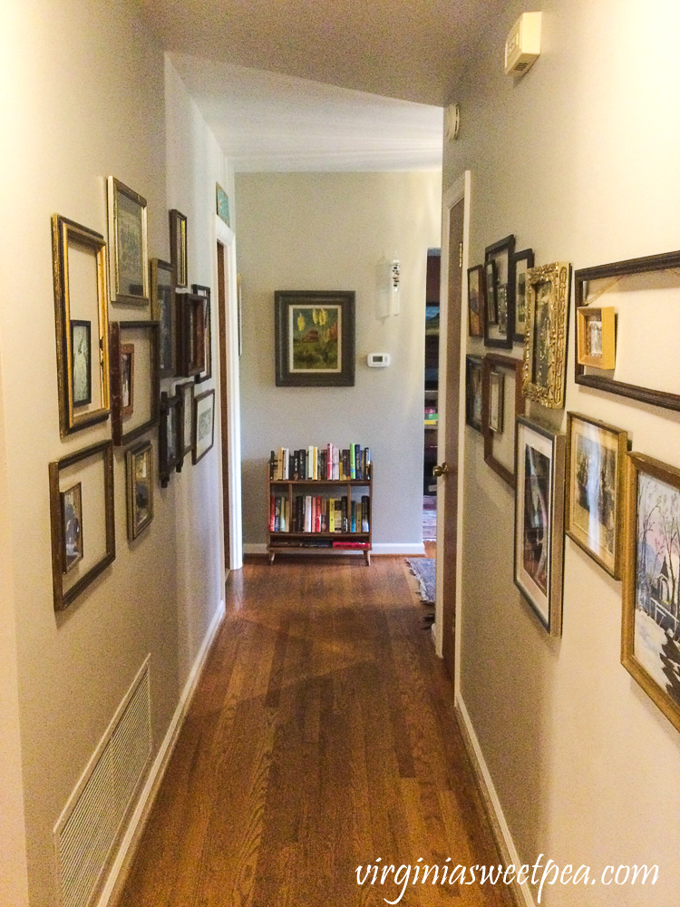 Hallway lined with frames hanging on the wall