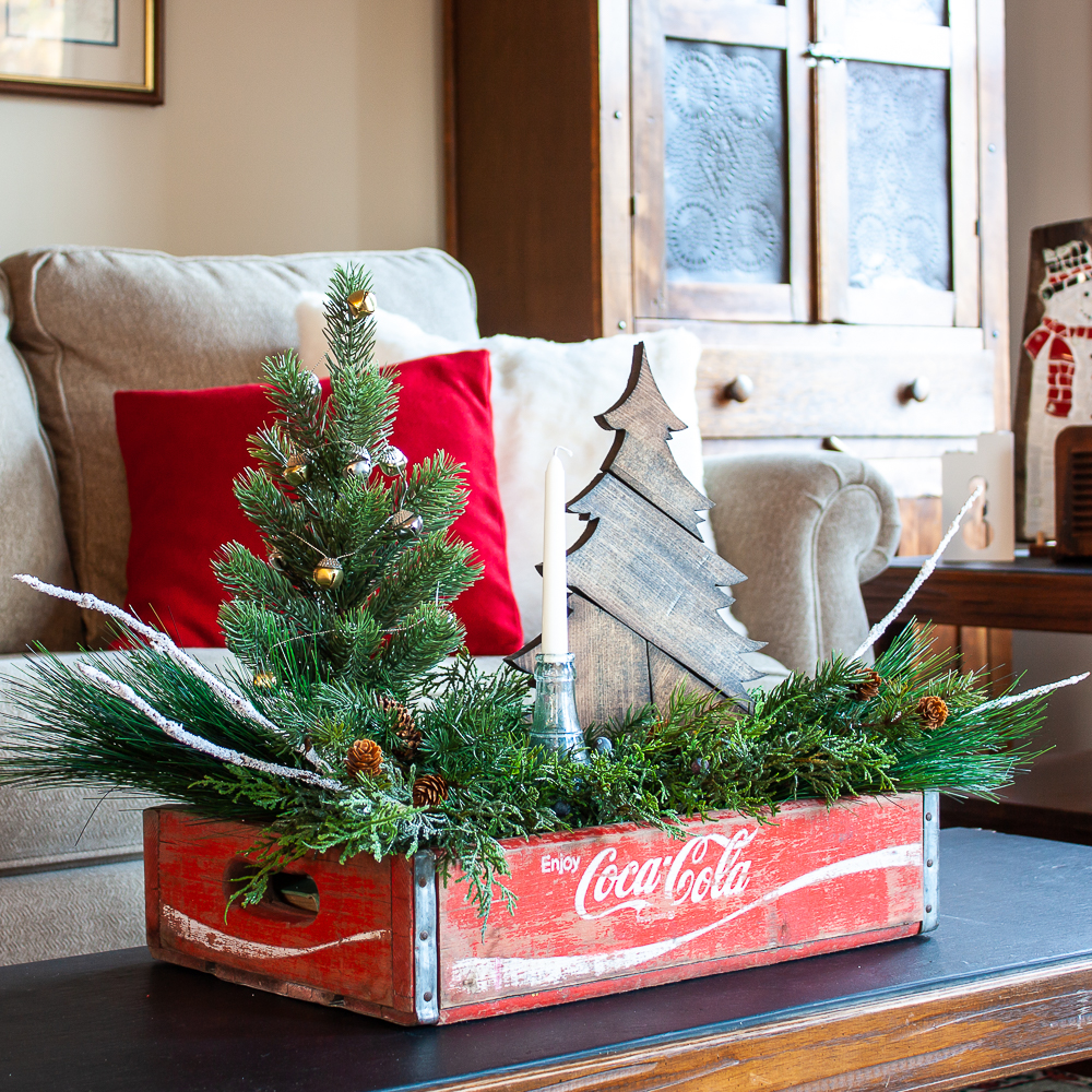 Vintage Coca-Cola crate decorated for Christmas on a coffee table