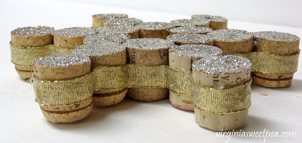 Side view of a snowflake made from wine cork halves with ribbon glued to the sides