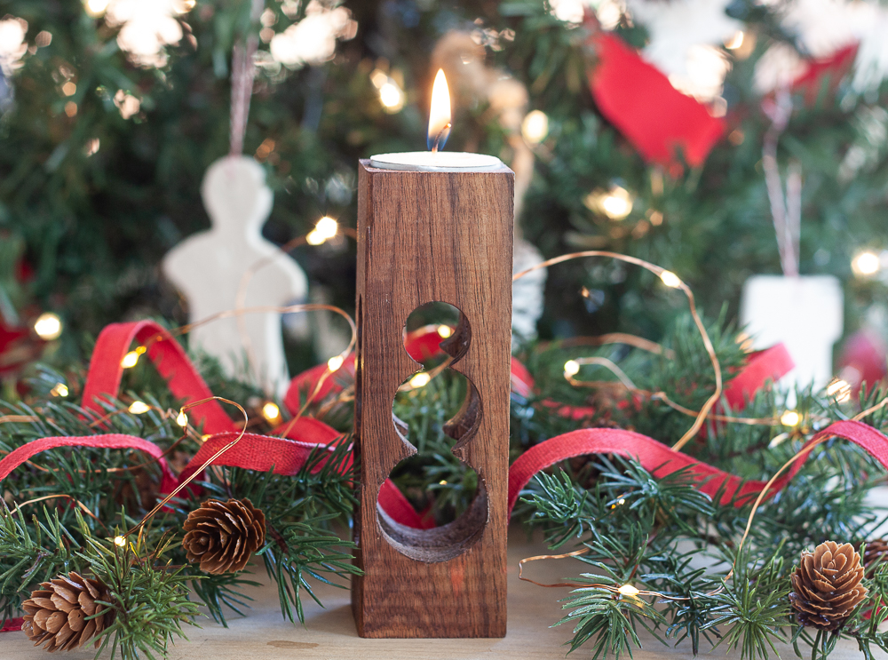 Candle holder with a cut into the wood snowman