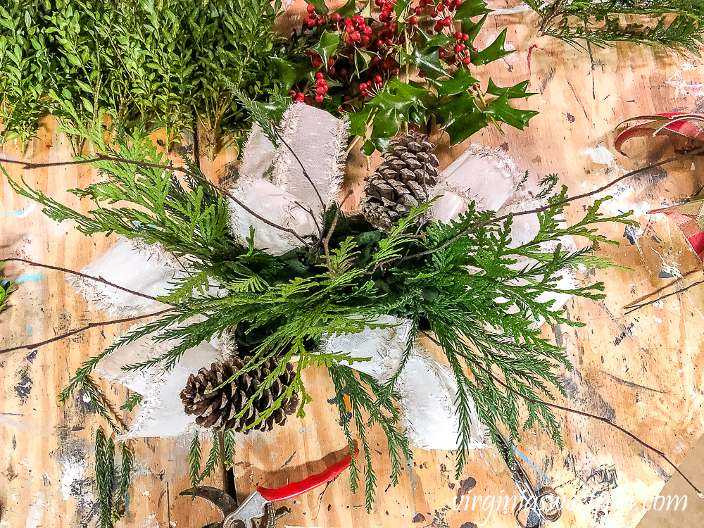 Greenery, pinecones, twigs, in a birch bark floral container