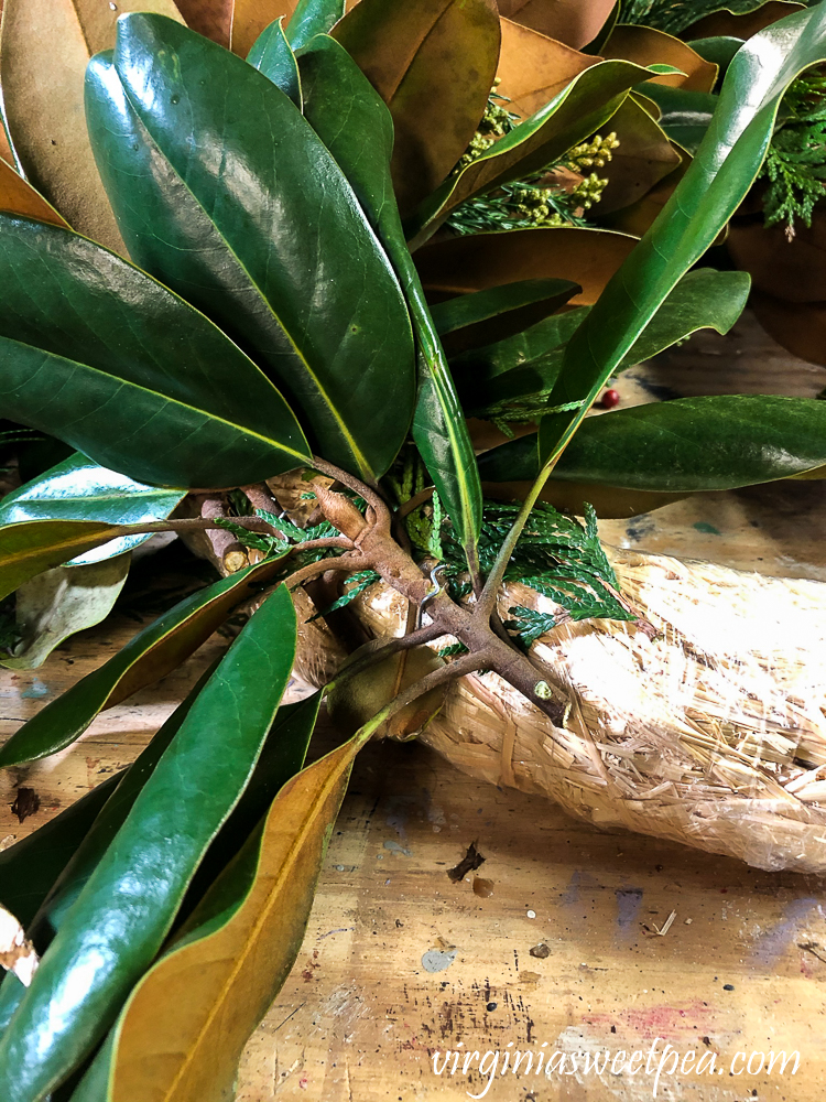 Magnolia stem pinned on a straw wreath form