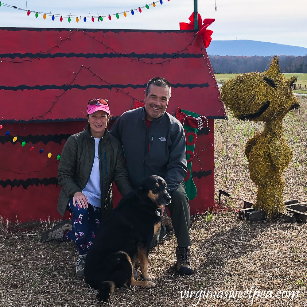 Family photo beside Snoopy's doghouse with Woodstock looking on