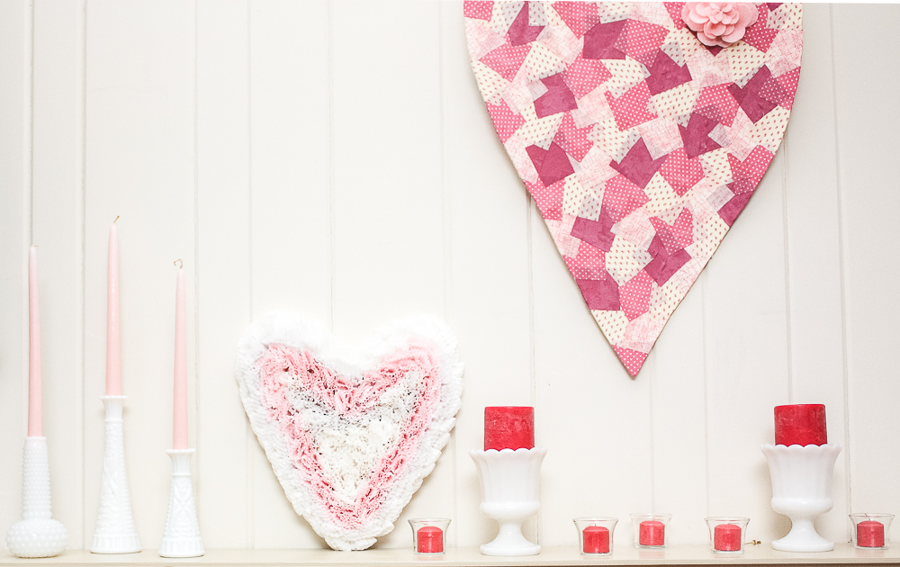 Valentine's Day mantel decor with two handmade heart crafts and milk glass vases with candles