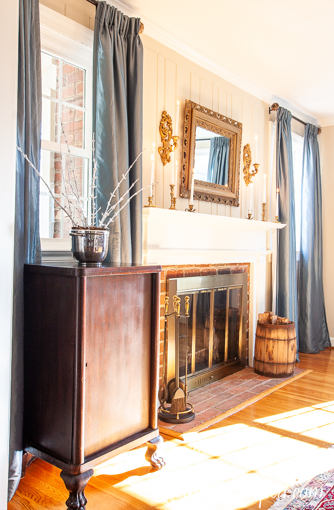 Living Room Winter Decor with icy branches, white candles, and gold