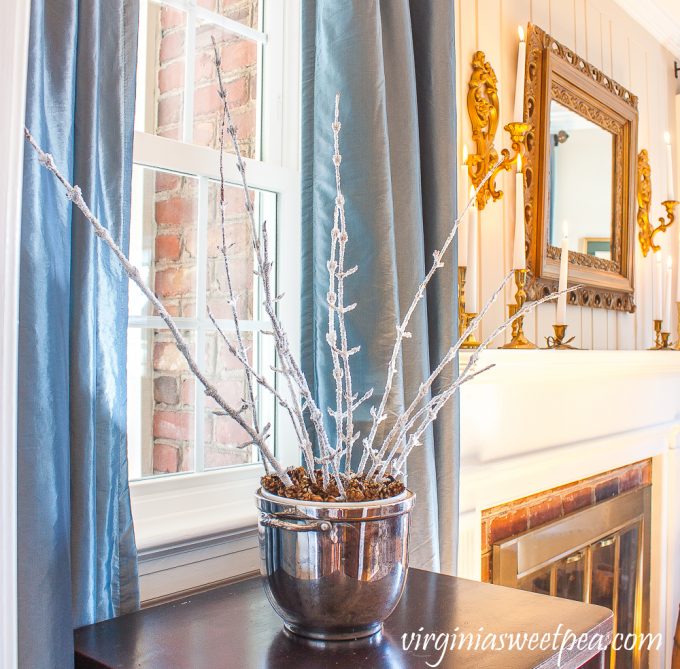 Winter Decor with icy branches, white candles, and gold