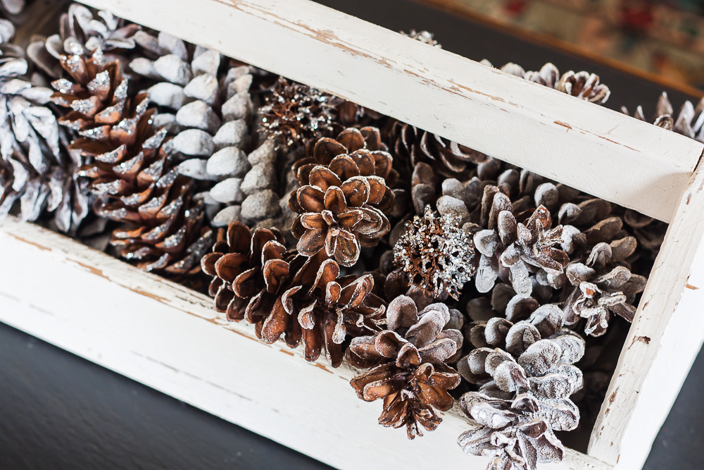 Pinecones and Sweet Gum Balls used for winter decor in a vintage toolbox.