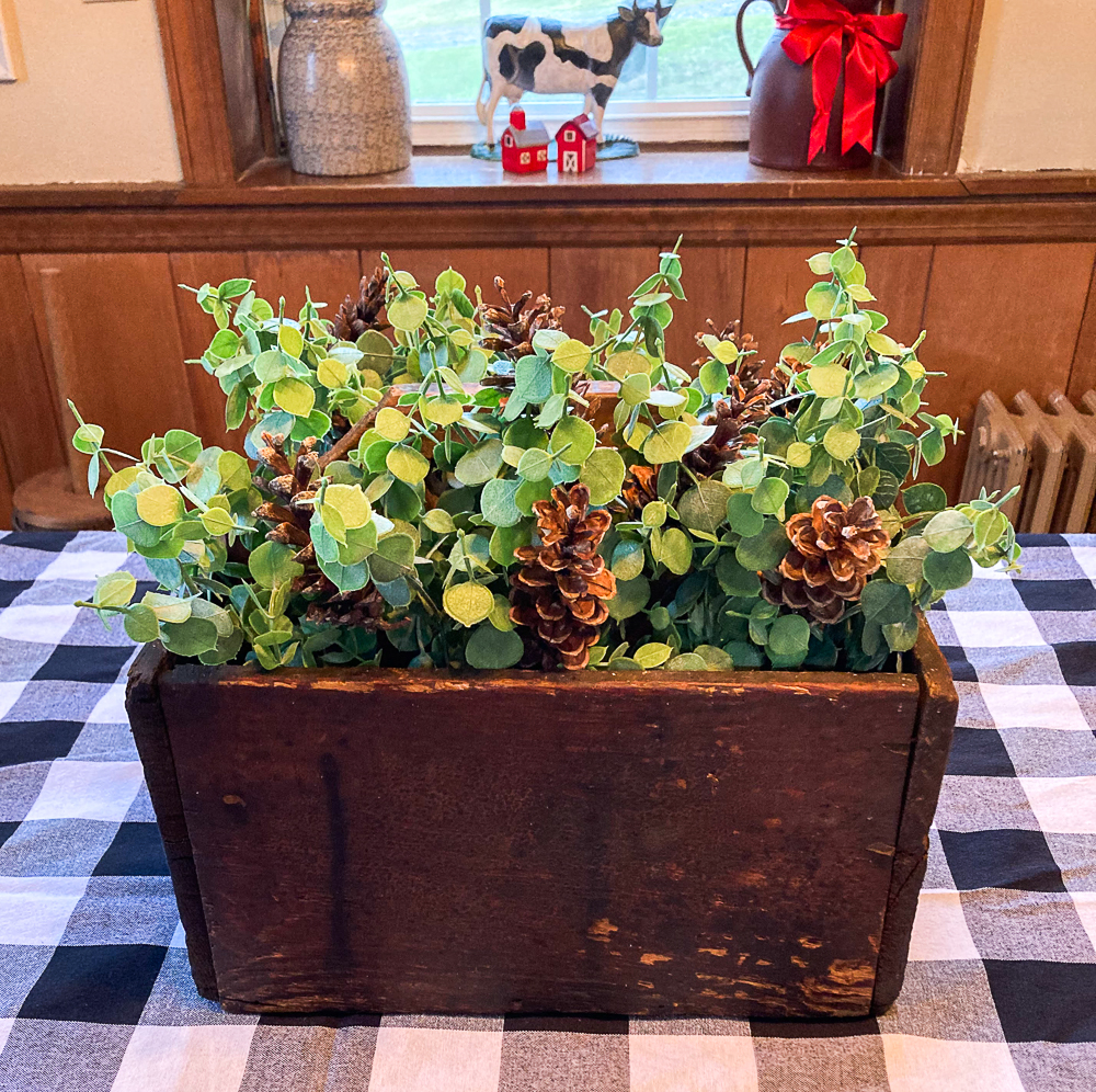 Vintage toolbox decorated with Eucalyptus and pinecones.