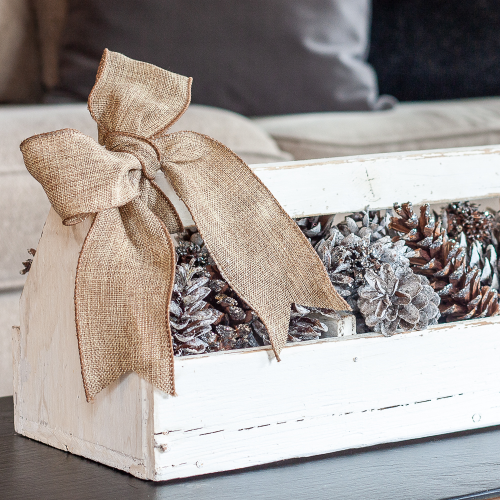 Handmade white toolbox filled with pinecones and glittered Sweet Gum balls
