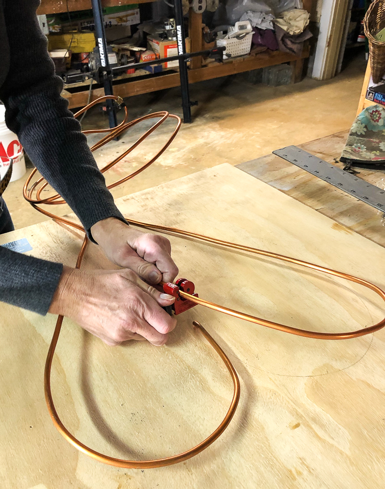 Using a pipe cutter to cut a copper pipe